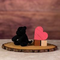 A black panther that is 5 inches tall while sitting next to wooden blocks