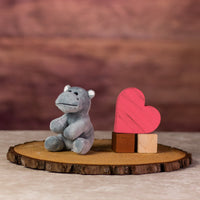 A gray hippo that is 5 inches tall while sitting next to wooden blocks