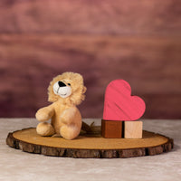 A beige lion that is 5 inches tall while sitting next to wooden blocks