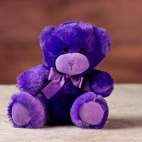 stuffed 6 in purple bright and cheery bear with bow around her neck