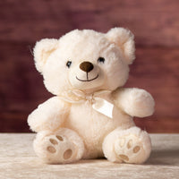 10 in stuffed cream bear wearing a bow