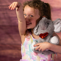 girl holding 9 in stuffed grey valentines elephant with heart