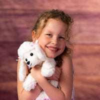 girl holding stuffed 10 in snow white poodle with pink bows on ears
