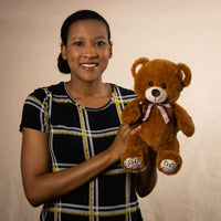 A woman holds a brown bear that is 13 inches tall while standing