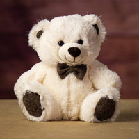 A off-white bear that is 10 inches tall while sitting wearing a bowtie that matches his ears and paw prints