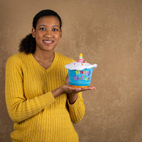 A woman holds a colorful animated/singing birthday cupcake that is 6 inches both tall and wide