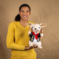 A woman holds a singing chihuahua that is 11 inches tall while sitting dressed as a mariachi band member holding two maracas