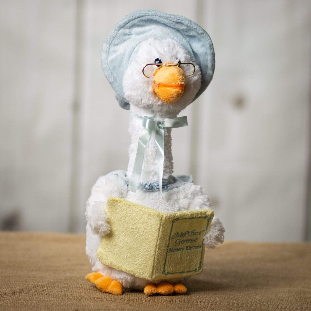 A white goose that is 14 inches tall while sitting wearing glasses and a light blue cap holding a nursery rhyme book