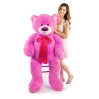 A woman next to a hot pink bear that is 60 inches tall while standing