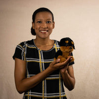 A woman holds a black and brown puppy that is 7 inches tall while sitting