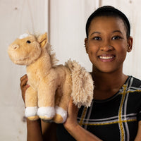 A woman holding a beige horse that is 10.5 inches tall from head to tail