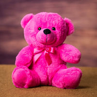A pink bear that is 9 inches tall while sitting 