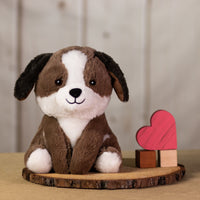 An oversized, white and brown dog that is 11 inches tall while sitting next to wooden blocks