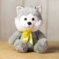 A gray husky that is 10 inches tall while sitting wearing a yellow bow