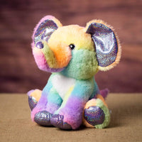 A rainbow elephant that is sitting sitting