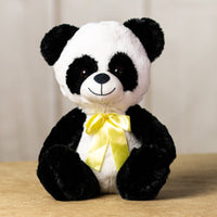 A black and white panda that is 10 inches tall while sitting wearing a yellow bow