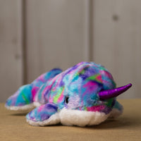 A psychedelic narwhal that is 14 inches long while sitting with a shiny purple horn and sparkly eyes