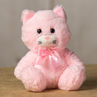 A light pink cat that is 7 inches tall while sitting wearing a matching bow