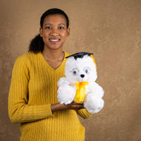 A woman holds a white grad bear that is 10 inches tall while standing