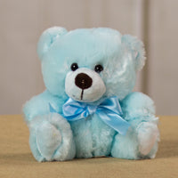 A blue bear that is 6 inches tall while sitting wearing a matching bow