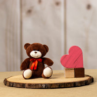 A brown bear that is 5.5 inches tall while sitting next to wooden blocks