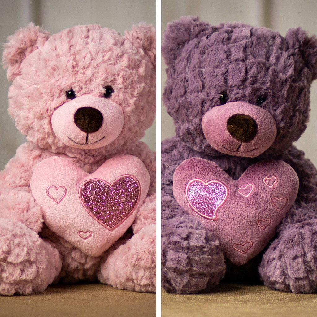 A pink and purple bears that are 10 inches tail while sitting holding a heart accented with smaller shiny hearts