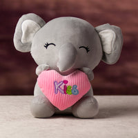 A gray elephant that is 10.5 inches tall while sitting holding valentine heart