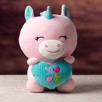 A pink unicorn that is 10.5 inches tall while sitting holding valentine heart