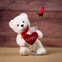 A standing white bear that is 8 inches tall while sitting holding a vase with a red Love heart wrapped around it