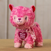 A pink llama that is 10 inches tall while standing with fluffy fur and a bright red heart that says "whole llama love" 