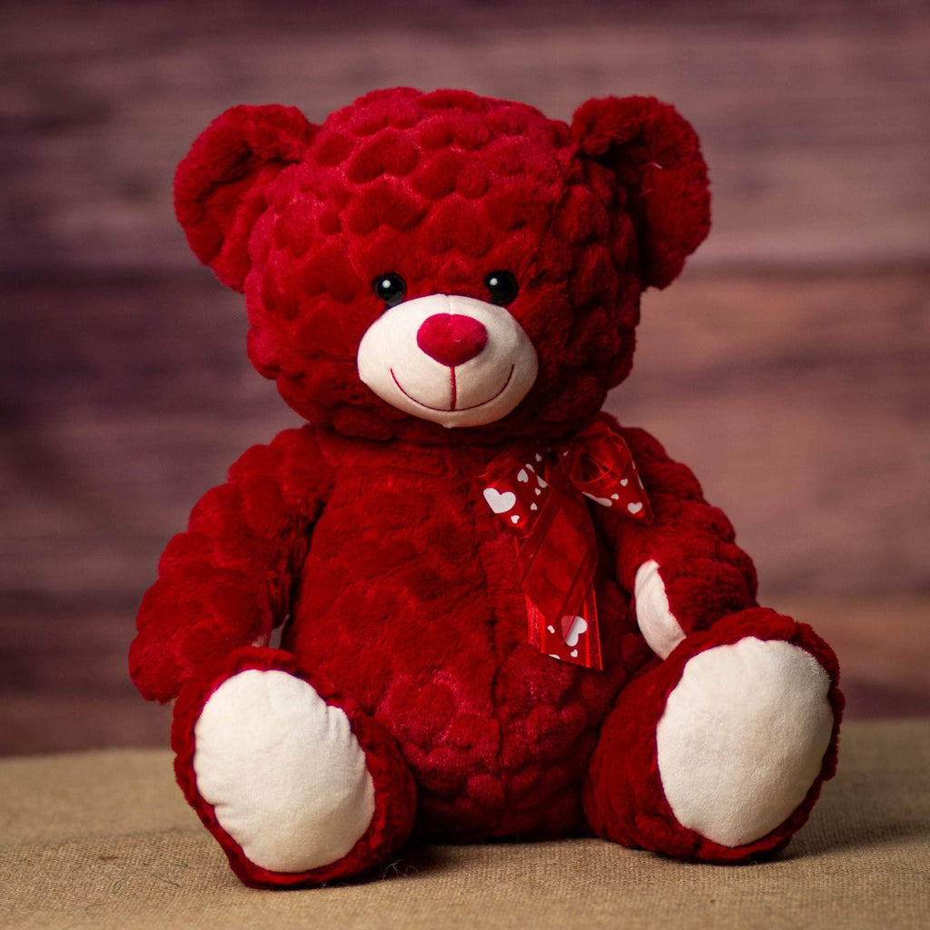 A large red bear with white feet and snout is sitting down