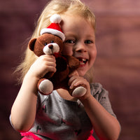 A little girl holding a brown bear that is 5.5 inches tall while sitting